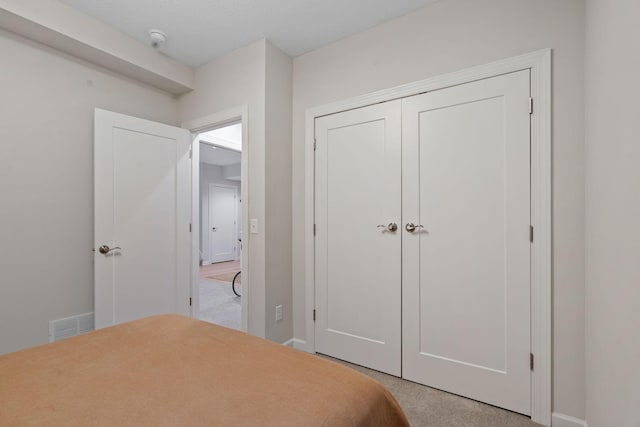 bedroom with light carpet and a closet