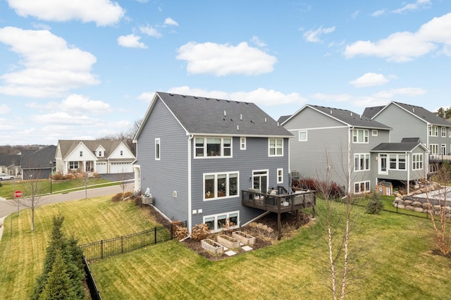 rear view of house with a wooden deck and a yard