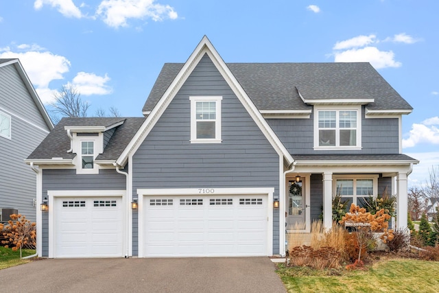 view of front facade with driveway and a shingled roof