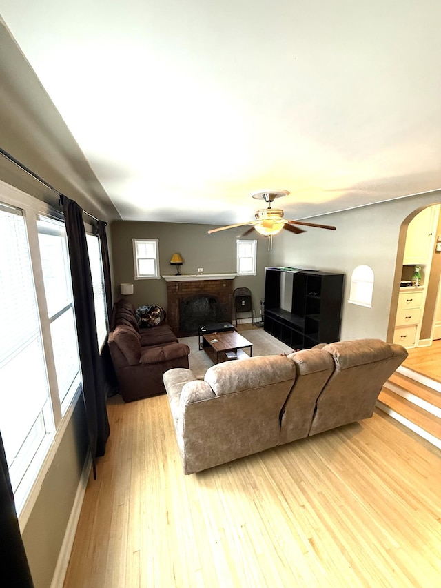 living room with ceiling fan, light hardwood / wood-style floors, and a fireplace