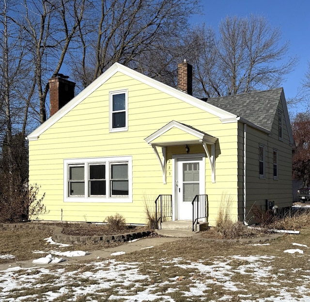 view of front of home with roof with shingles and a chimney