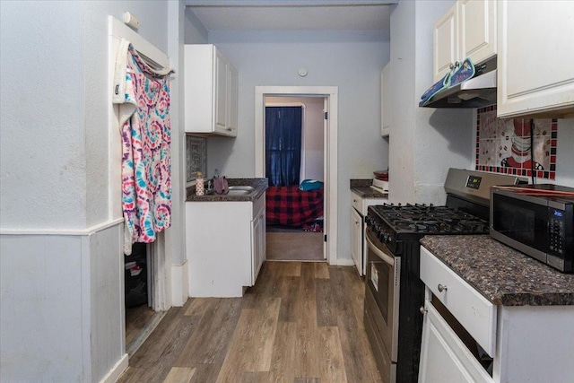 kitchen with white cabinets, stainless steel appliances, and hardwood / wood-style floors