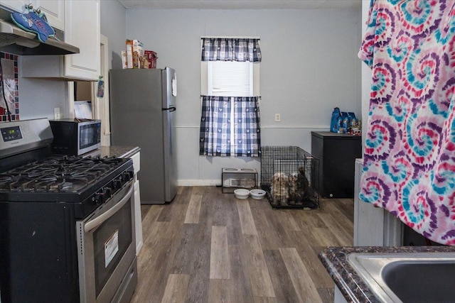 kitchen with white cabinets, stainless steel appliances, and dark hardwood / wood-style floors