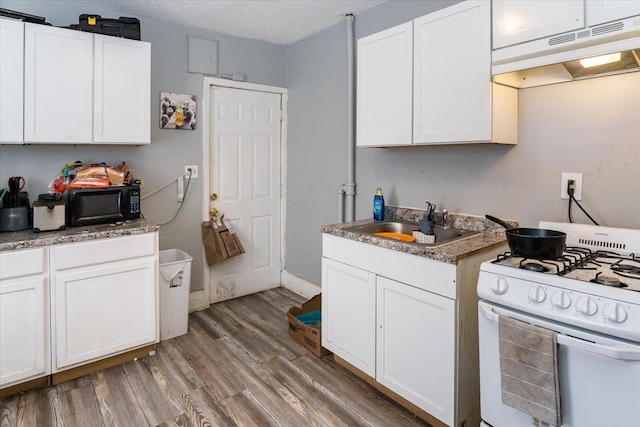 kitchen featuring white gas range, white cabinetry, sink, and a textured ceiling