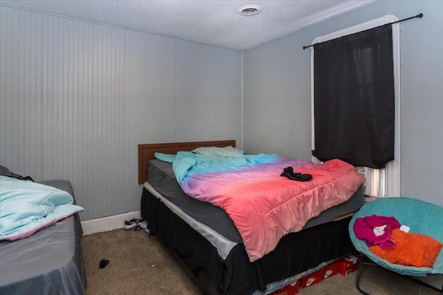 bedroom with a textured ceiling and light carpet