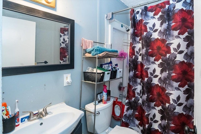 bathroom featuring a shower with curtain, toilet, and sink