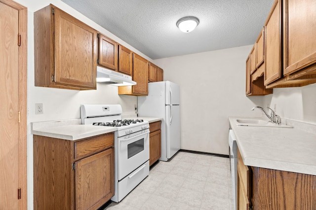 kitchen with sink, white appliances, and a textured ceiling