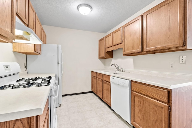 kitchen featuring white appliances, sink, and a textured ceiling