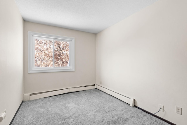 spare room with a textured ceiling, light colored carpet, and a baseboard heating unit