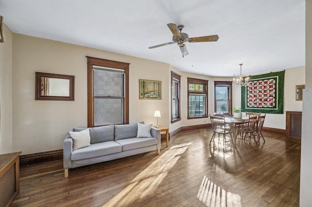 living room featuring dark wood-type flooring and ceiling fan with notable chandelier