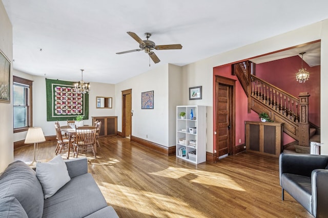 living room featuring ceiling fan with notable chandelier and hardwood / wood-style floors