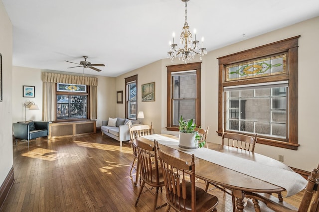 dining area featuring ceiling fan with notable chandelier and dark hardwood / wood-style flooring