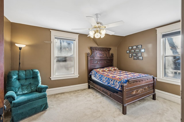 carpeted bedroom with ceiling fan, multiple windows, and vaulted ceiling