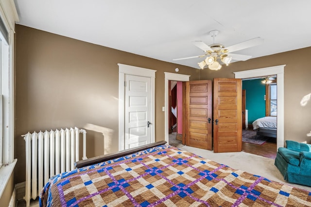 bedroom featuring ceiling fan, radiator, and light carpet