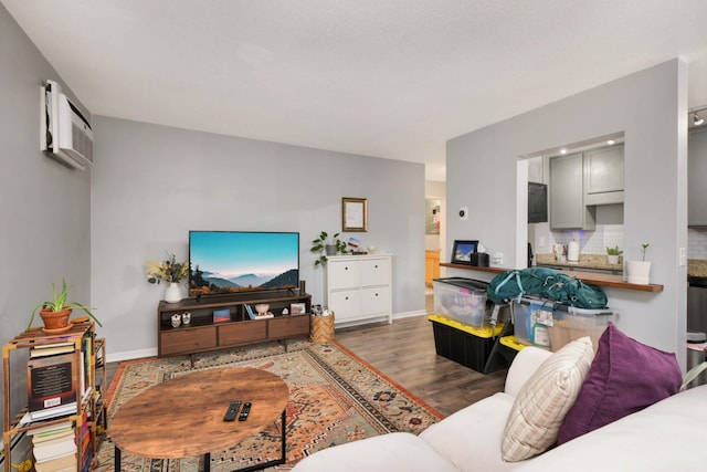 living room featuring dark hardwood / wood-style flooring and an AC wall unit