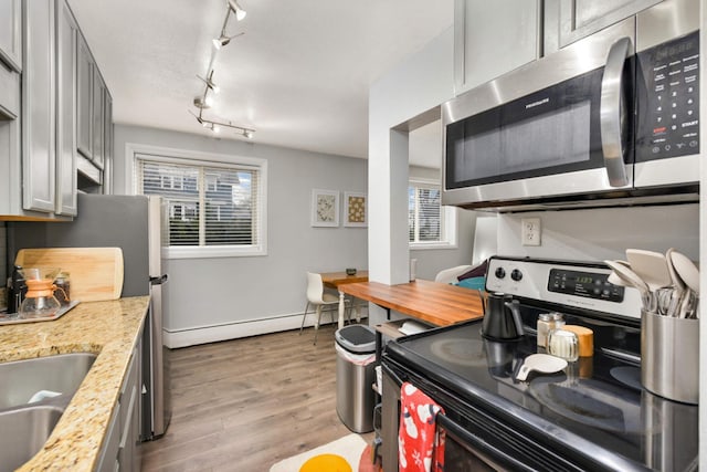 kitchen with stainless steel appliances, light hardwood / wood-style flooring, plenty of natural light, and gray cabinetry