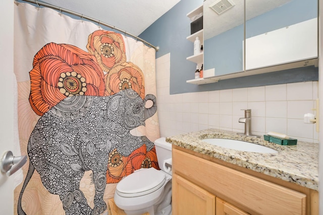 bathroom featuring decorative backsplash, vanity, toilet, and tile walls