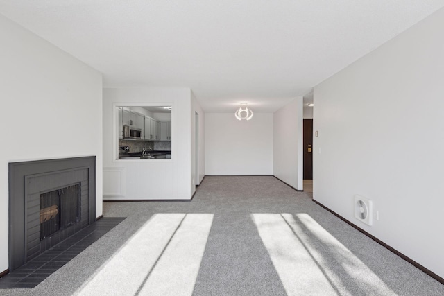 unfurnished living room featuring dark colored carpet and sink