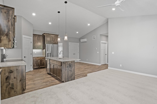 kitchen featuring a center island with sink, sink, hanging light fixtures, ceiling fan, and stainless steel appliances