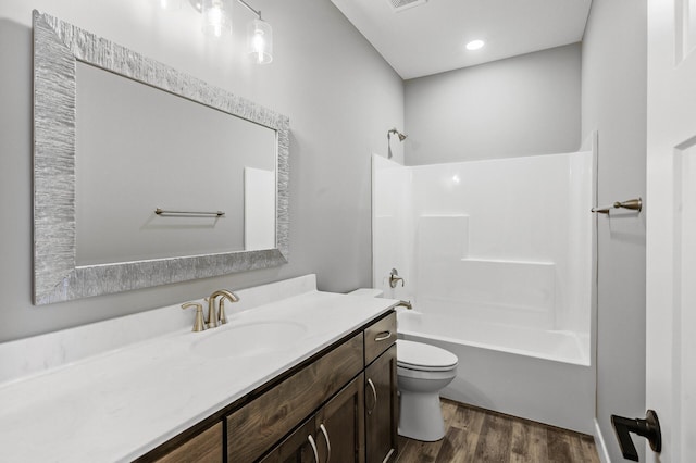 full bathroom with hardwood / wood-style floors, vanity, toilet, and washtub / shower combination