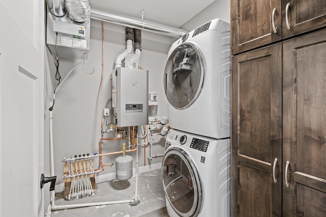 washroom featuring cabinets, stacked washer and dryer, and water heater