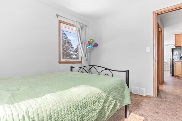 bedroom with visible vents, baseboards, carpet flooring, and freestanding refrigerator