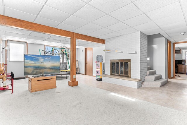 carpeted living area with stairway, a paneled ceiling, and a fireplace