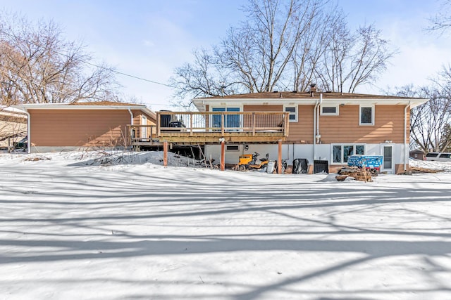 snow covered rear of property featuring a wooden deck