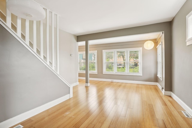 unfurnished living room featuring a wealth of natural light and light hardwood / wood-style flooring