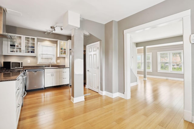 kitchen featuring white cabinetry, wall chimney exhaust hood, stainless steel appliances, and light wood-type flooring