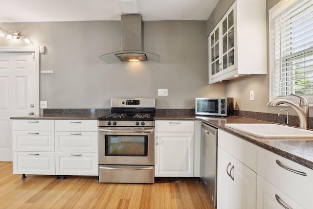 kitchen featuring white cabinets, sink, light hardwood / wood-style floors, island range hood, and stainless steel appliances