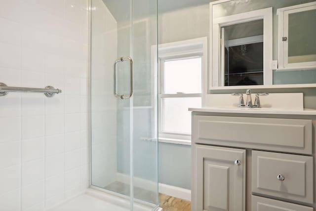 bathroom with vanity, hardwood / wood-style flooring, and a shower with door