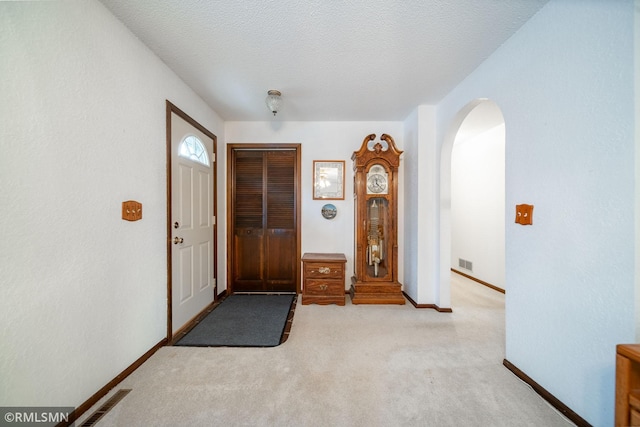 carpeted entrance foyer featuring a textured ceiling