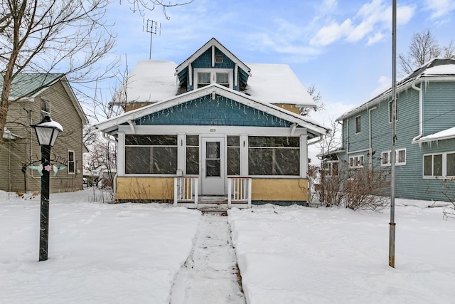 snow covered property with a sunroom