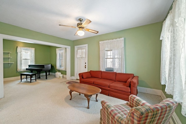 living area with light carpet, ceiling fan, and baseboards