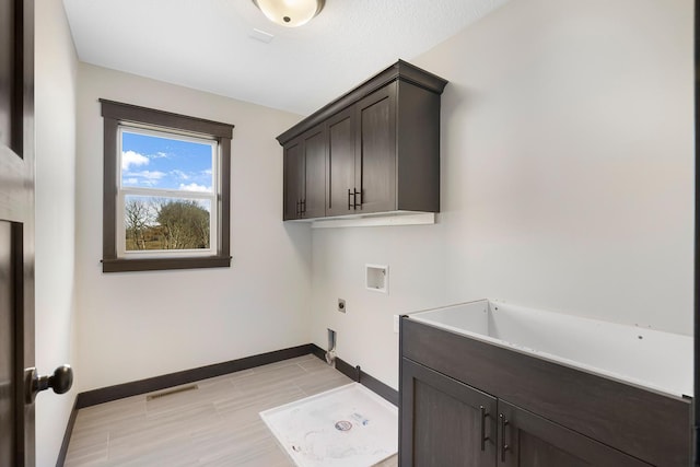 clothes washing area with electric dryer hookup, cabinets, and hookup for a washing machine