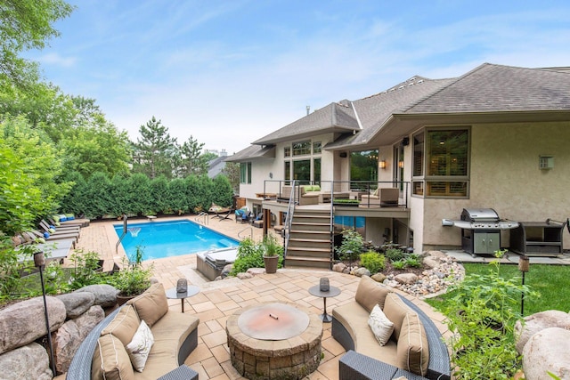 view of swimming pool featuring area for grilling, an outdoor living space with a fire pit, and a patio area