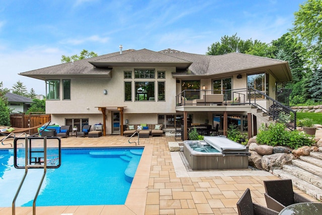 rear view of house with a swimming pool with hot tub, an outdoor living space, and a patio