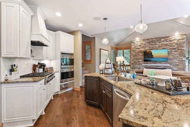 kitchen with sink, white cabinetry, decorative light fixtures, stainless steel appliances, and light stone countertops