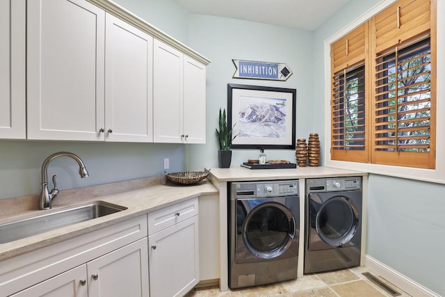 laundry room with cabinets, separate washer and dryer, and sink