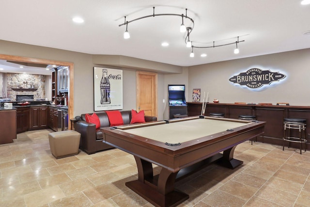 rec room featuring a stone fireplace and billiards