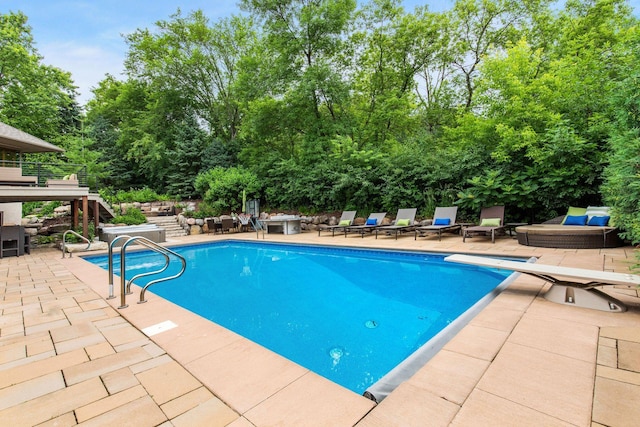 view of pool with a patio, an outdoor living space, and a diving board