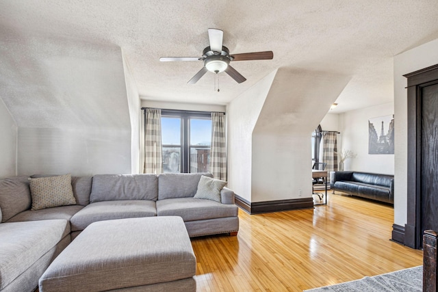 living room with hardwood / wood-style flooring, ceiling fan, and a textured ceiling