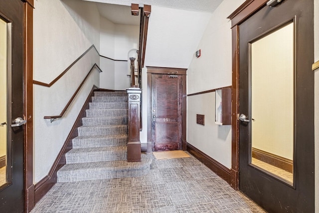 stairway with carpet flooring and vaulted ceiling