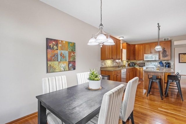 dining space with sink and light hardwood / wood-style flooring