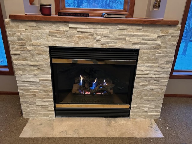 interior details featuring carpet floors, a fireplace, and baseboards