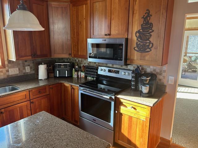 kitchen with appliances with stainless steel finishes and brown cabinetry