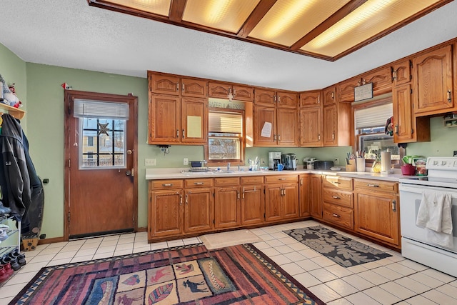 kitchen featuring a textured ceiling, electric stove, and light tile patterned floors