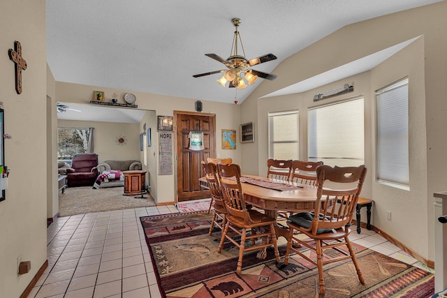 dining room featuring lofted ceiling, a textured ceiling, ceiling fan, and light tile patterned floors