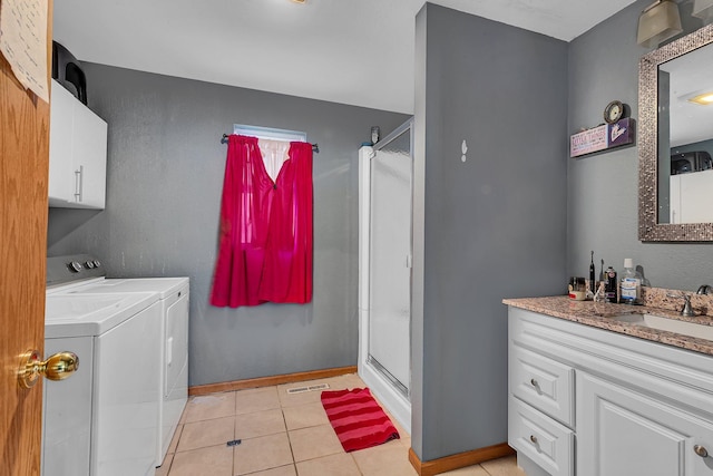 clothes washing area with sink, washer and dryer, and light tile patterned floors